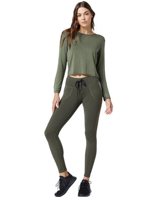 Front of model wearing the asher pullover in olive with Body Language Sportswear leggings